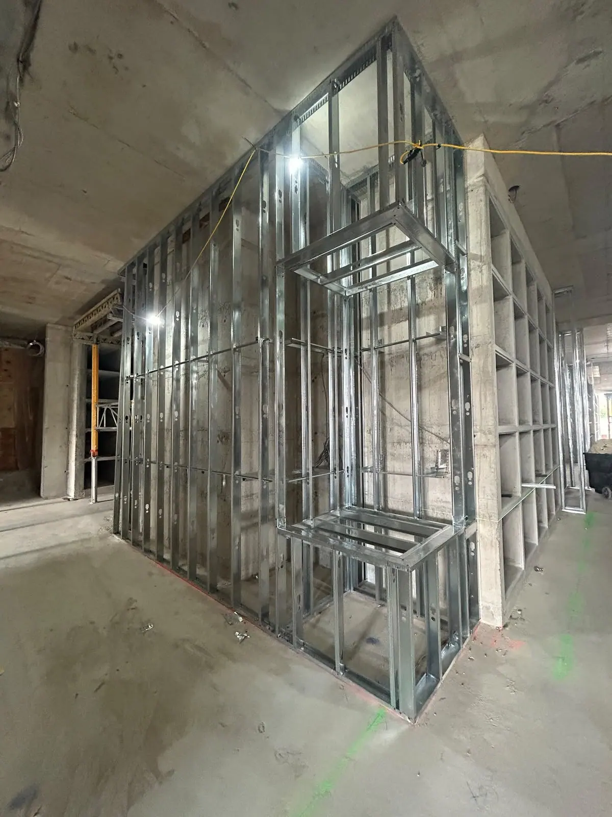 Metal-stud interior partitions with a framed opening in an unfinished concrete space