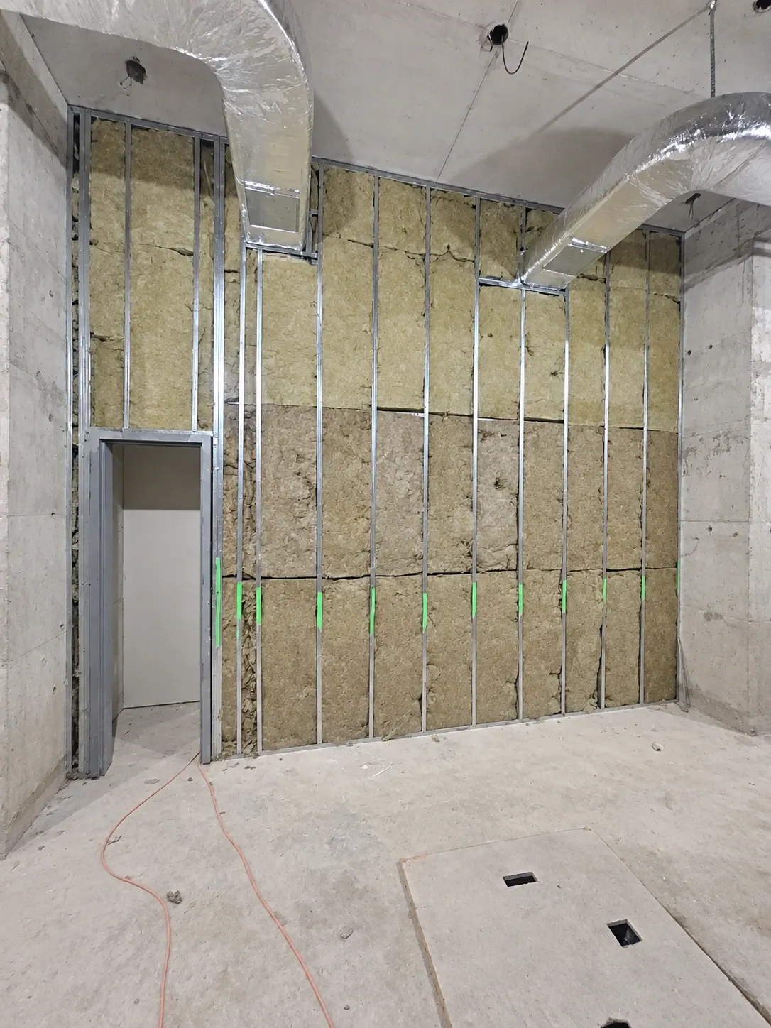 Insulation batts placed between metal wall studs in an unfinished interior