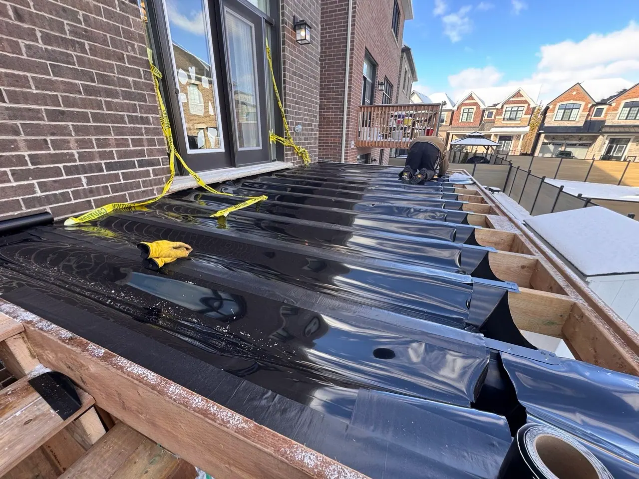 Raised deck framing with dark sheet material during construction